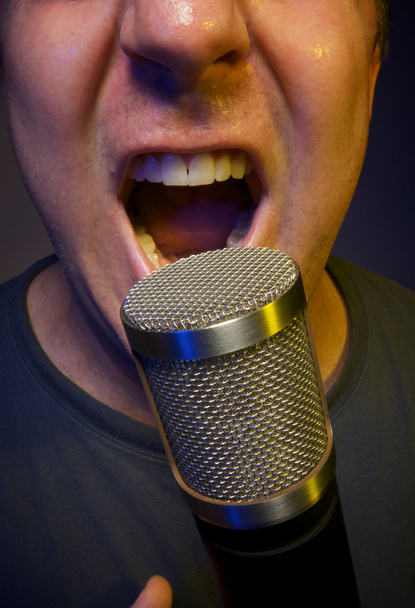 Vocalista apasionado usando micrófono
 - Foto, Imagen