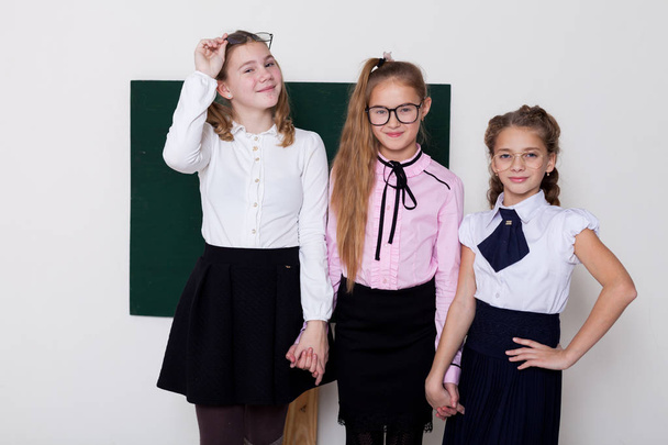 три девочки в очках за классной доской на уроке
 - Фото, изображение