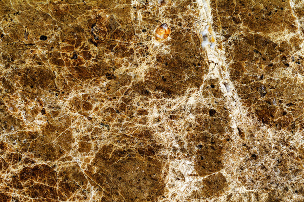 όμορφη παλιά κίτρινο-καφέ διακοσμητική πέτρα μαρμάρινο αφηρημένο ρωγμές και λεκέδες στην επιφάνεια ως φυσικό υπόβαθρο - Φωτογραφία, εικόνα