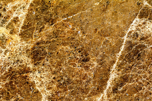 mooie oude geel-bruine decoratieve steen marmeren abstract scheuren en vlekken op het oppervlak als natuurlijke achtergrond - Foto, afbeelding