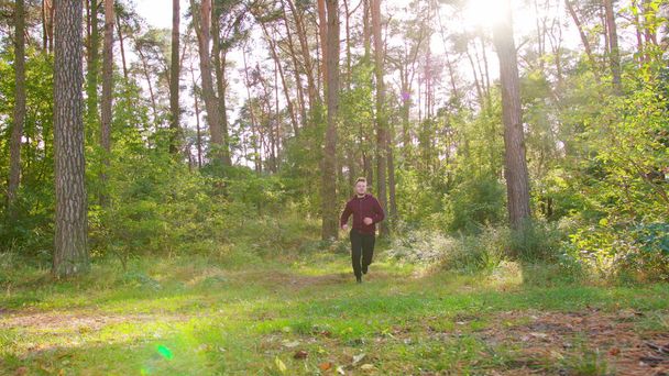Молодий чоловік біжить у лісі
 - Фото, зображення