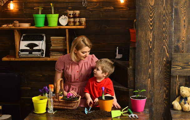 Cultivate concept. Mother and son cultivate flower in pot. Mother and child cultivate potted flower. Cultivate the soil - Foto, Imagen