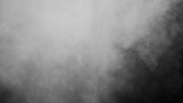 Des nuages blancs de fumée de vapeur sont isolés sur un fond noir. Le gaz explose, tourbillonne et danse dans l'espace. Un effet de texture de poussière de brouillard magique qui peut être utilisé en superposant et en changeant leur transparence
. - Photo, image