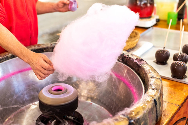 Ladenbesitzer bereitet Zuckerwatte auf Jahrmarkt für einige Kinder zu. - Foto, Bild