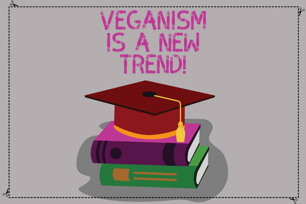 Kavramsal el veganism var A yeni eğilim gösteren yazma. İş fotoğraf metin sağlıklı yiyecek vegan yaşam tarzı taze yemekler diyet renk mezuniyet şapka püskül ile 3d akademik kitaplar üzerinde kap. - Fotoğraf, Görsel