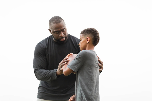 American Football coach training a young athlete. - Photo, image