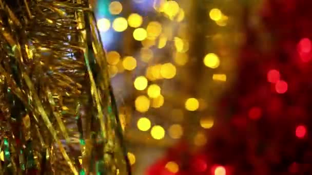 Boże Narodzenie i nowy rok uroczystości wakacje. Złote ozdoby świąteczne blichtr garland dmuchanie na wietrze. Niewyraźne lights Christmas migać w tle. - Materiał filmowy, wideo