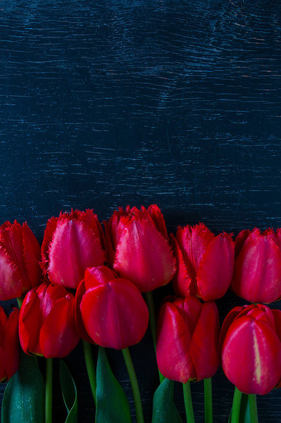 beautiful red tulips on dark wooden surface - Zdjęcie, obraz