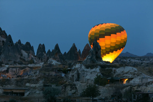 Colorful Hot Air Balloon Illuminating Behind Rocks In Night - Фото, изображение