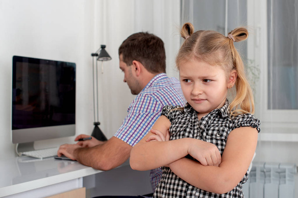 小さな女の子と彼女の父親のスタジオ撮影。彼はゲームのための彼女の少しの時間を与えるために、娘は彼女の父で犯罪を取ります。父はコンピューターで座っています。. - 写真・画像