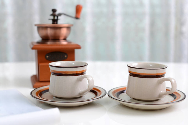 Moinho de café com xícaras de café na mesa
 - Foto, Imagem