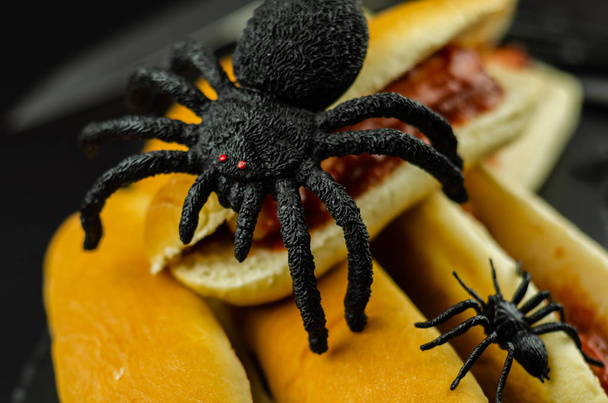 Creepy Halloween hotdog fingers on the black table, party food - Photo, Image