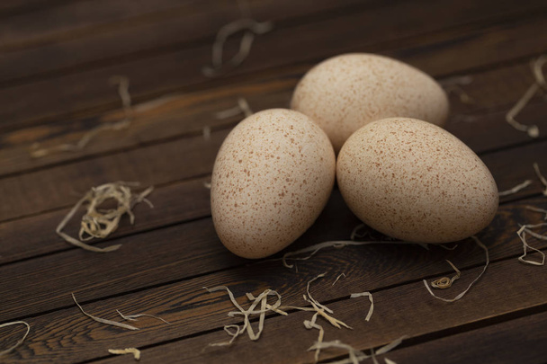 Group of three fresh turkey eggs on a wooden table - Photo, image