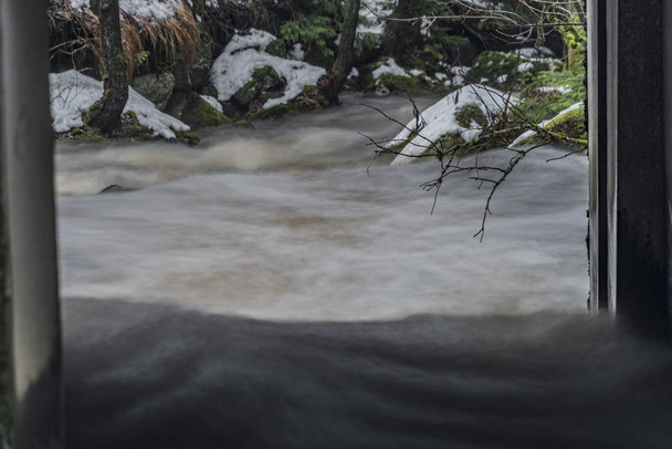 Overflow fast river Bystrice in Krusne mountains in winter morning - Photo, Image