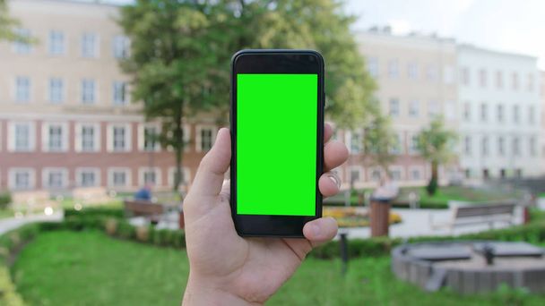 Une main tenant un téléphone avec un écran vert
 - Photo, image