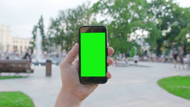 Una mano che tiene un telefono con uno schermo verde
 - Foto, immagini