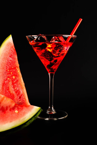 Red refreshing drink on the basis of watermelon on a black background, party night - Photo, image
