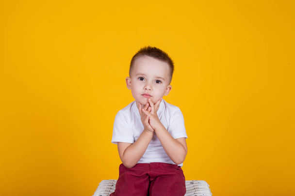 Πορτρέτο του ένα όμορφο αγόρι, σε κίτρινο φόντο, και τέσσερα χρόνια - Φωτογραφία, εικόνα