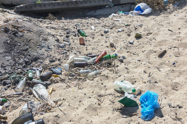 Rozlane śmieci na plaży duże miasto. Puste używane brudnych plastikowych butelek. Brudne morze piaszczysta brzegu Morza Czarnego. Zanieczyszczenie środowiska. Problem ekologiczny. Wysypisko śmieci w pobliżu ogrodzenia publicznej plaży - Zdjęcie, obraz