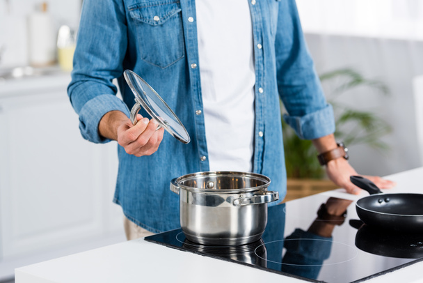 cropped view of man cooking food in pot at kitchen  - Foto, Bild