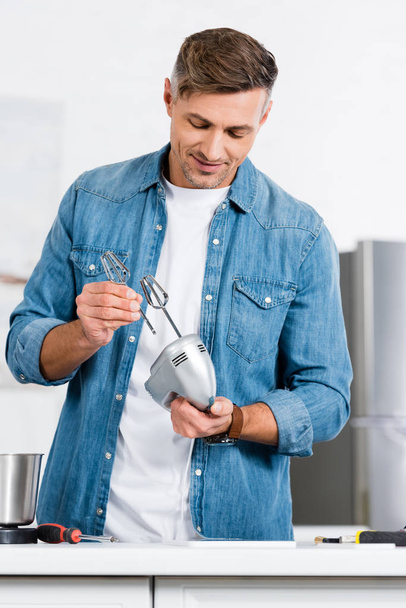 cropped view of man putting whisk into kitchen mixer - Zdjęcie, obraz