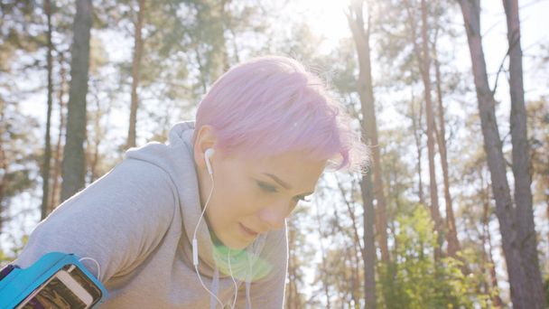 森の中ジョギング ピンクの髪をもつ若い女性 - 写真・画像