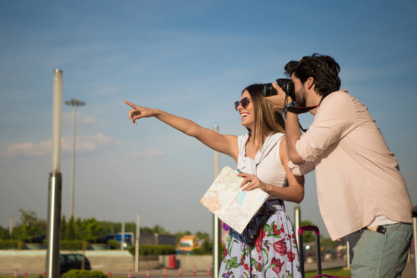 A beautiful young woman and her handsome boyfriend are looking at a famous monument, and he is taking a photo of it. - Photo, Image