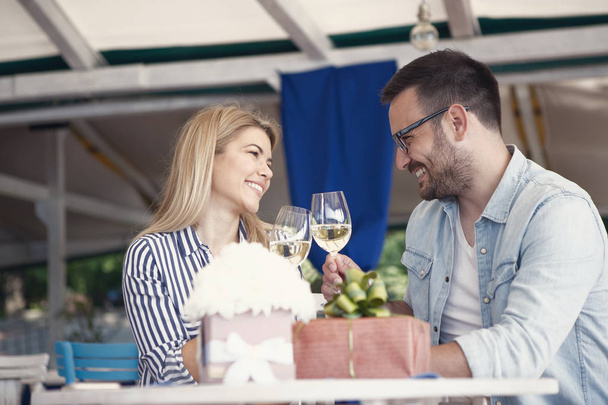 若い夫婦は、その最初の記念日を祝っています,白ワインで乾杯し、彼らは非常に満足しています. - 写真・画像