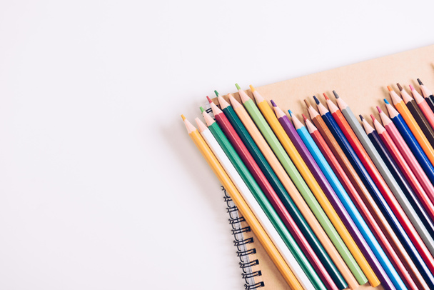 notebook, fehér háttér fából készült színes ceruza készlet - Fotó, kép