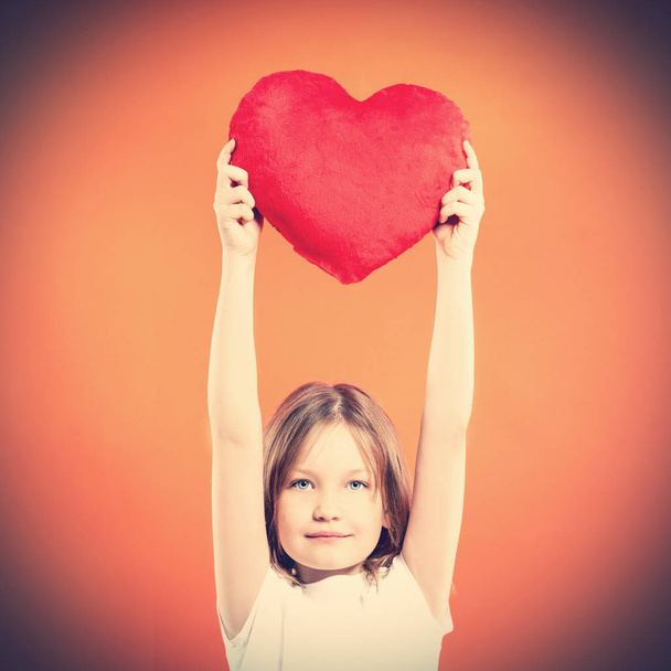 Cute little girl holding red heart over red background. Love concept. Valentine's Day. Mothers Day. - Zdjęcie, obraz