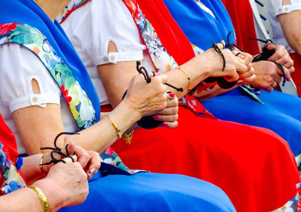 close up hands with castanets of women during the presentation of a group cultivating the Spanish tradition, musical instruments - Photo, Image