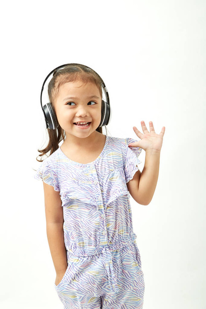 Asian Little girl in headphones listening to the music and looking to the copy space area - Foto, immagini