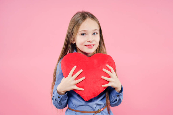Love concept. Cute child girl holding red heart over pink background. Valentine's Day. Mothers Day. - Valokuva, kuva