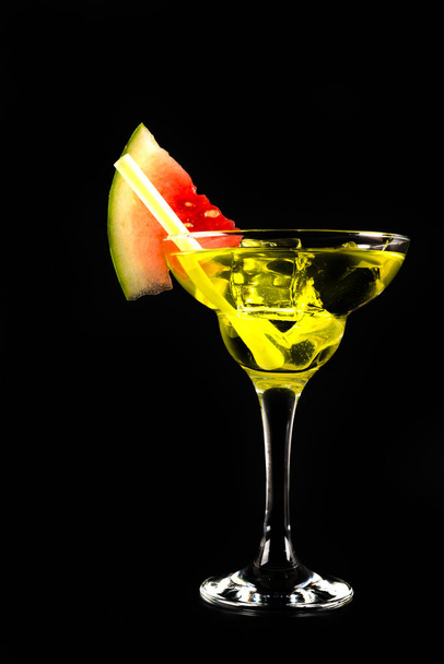 green refreshing drink on the basis of pear with decorated watermelon on a black background, party night - Photo, Image