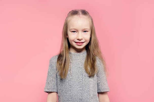 Portrait of a happy child girl over pink background. - Foto, afbeelding