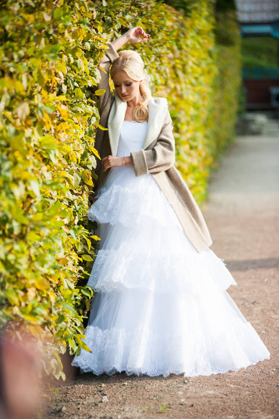 Smyslná nevěsta blondýnka ve svatebních šatech v blízkosti paláce před svatební obřad - Fotografie, Obrázek