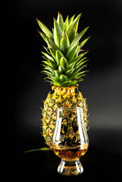 Schotse whisky in een glas met ananas, gouden kleur whiskey, exclusieve drank - Foto, afbeelding