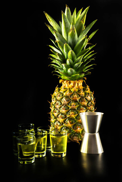Bebidas saborosas e coloridas à base de vários álcoois, xaropes e licores no fundo de abacaxi, o efeito único do trabalho do barman, noite de festa
 - Foto, Imagem