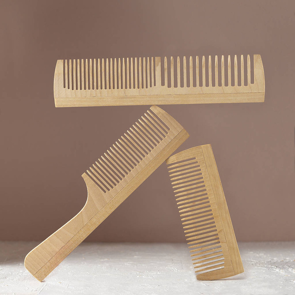 Wooden hair combs balancing over brown background - Photo, Image