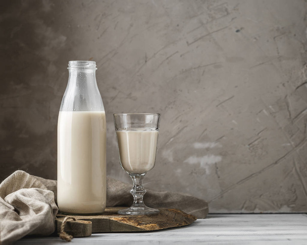 Bottiglia di vetro riutilizzabile di latte fresco su sfondo rustico
 - Foto, immagini