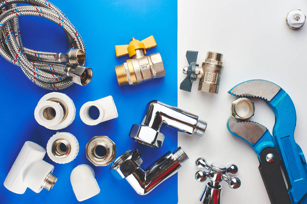 Plumbing parts, accessories and tools on a blue white background. - Fotó, kép
