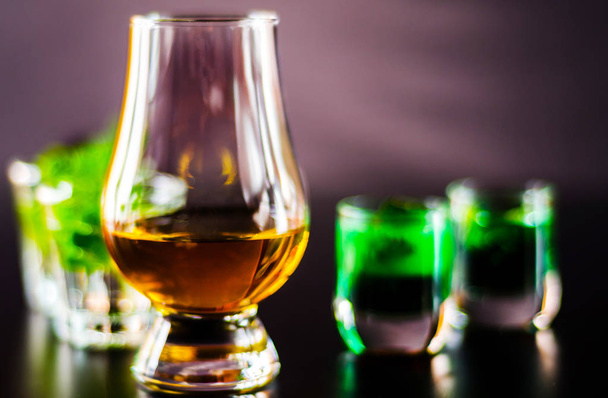 whisky single malt in un bicchiere e liquore alla menta verde, set rinfrescante di bevande, sensazioni gustative
 - Foto, immagini