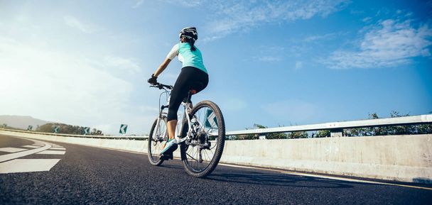 Woman cyclist  riding Mountain Bike on highway - Foto, Imagen