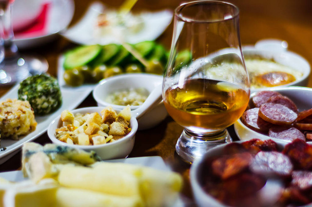 bicchiere di whisky single malt e set con diversi antipasti in piccole porzioni, deliziosi snack e bevande
 - Foto, immagini