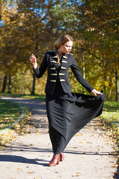 Full body, Young beautiful blonde woman in long black dress on the autumn park - Фото, изображение