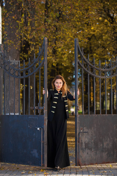 Full body, Young beautiful blonde woman in long black dress on the autumn park - Photo, image