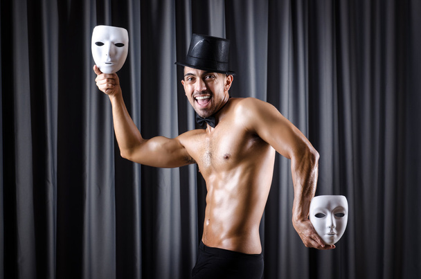 Muscular actor with mask against curtain - Photo, Image