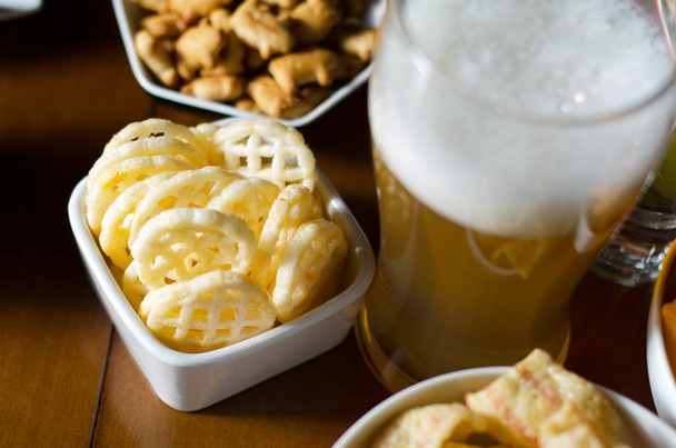set of various snacks, pint of lager beer in a glass, a standard set of drinking and eating in a pub, beer and snacks - Фото, зображення