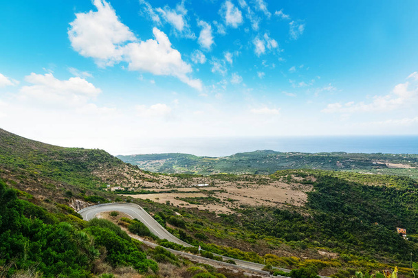 kurvenreiche Straße auf einem grünen Hügel in Sardinen, Italien - Foto, Bild