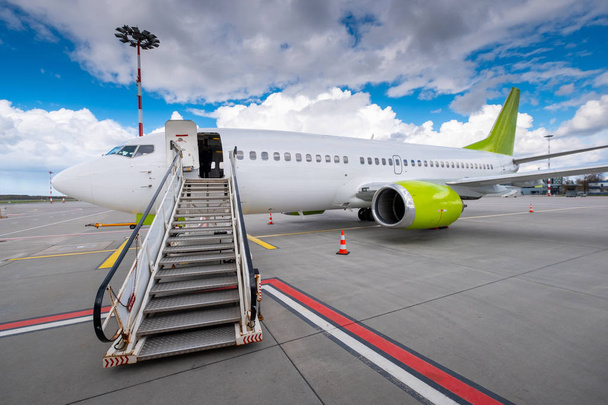 Lentokone odottaa matkustajia lentokentällä
 - Valokuva, kuva